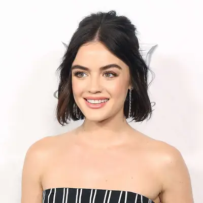 Lucy Hale wears her bob in a half-up hairstyle with some teasing at the crown and a center part.