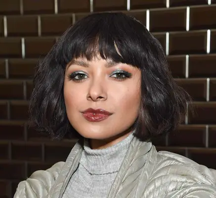 Kat Graham wears a heavy fringe to frame her thick wavy bob and 90s inspired makeup during fashion week