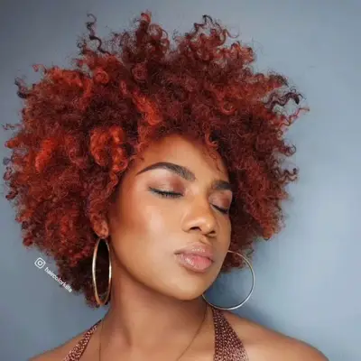 Person with auburn and cherry red curly hair 
