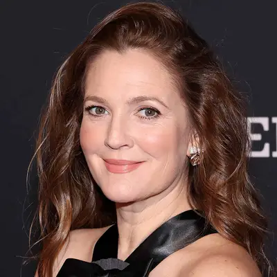 Drew Barrymore with dark wavy hair and black halter-neck dress attends the 24th Annual Mark Twain Prize For American Humor