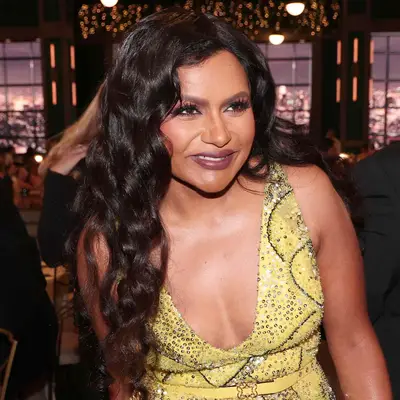 Mindy Kaling with long glossy mermaid waves and yellow dress at 74th ANNUAL PRIMETIME EMMY AWARDS 
