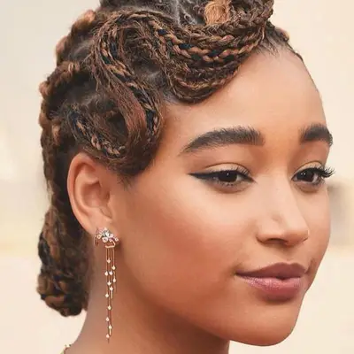 Actor Amandla Stenberg with a cornrow hairstyle in a soft, old Hollywood wave 