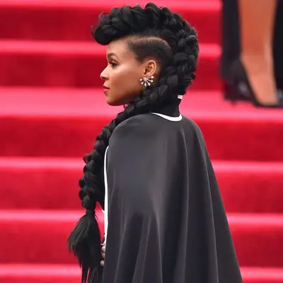 Actor Janelle Monet with cornrows down the side of her head, the center of her hair piled into one giant mohawk cornrow
