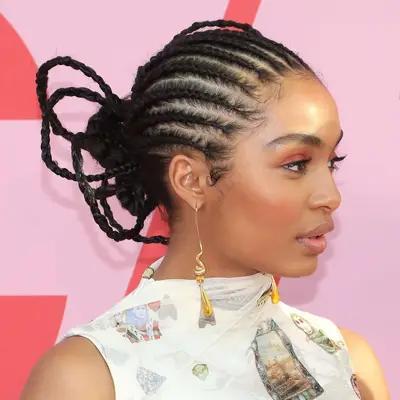 Actor Yara Shahidi viewed in profile, her hair half cornrowed, half in an architectural bun in the back