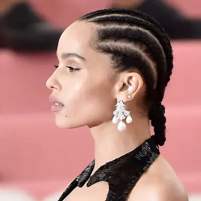 Actor Zoe Kravitz in side profile, her hair in a straight back cornrow hairstyle