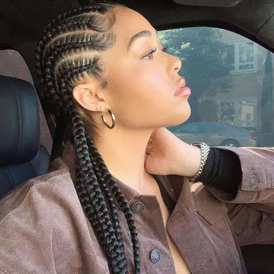 Side profile of socialite Jordyn Woods, her hair cornrowed and baby hair layed in swoops