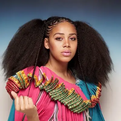 A cornrow half-crown hairstyle with a braided front and full, afro back