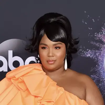 lizzo with orange dress and ponytail at 2019 American Music Awards