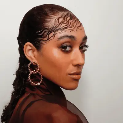 Rihanna with parted wispy bangs in brown silk top