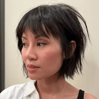 Tyra Banks with blown out wispy bangs and messy waves