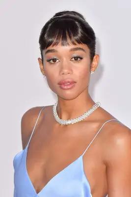 Laura Harrier with baby bangs, necklace, and sky blue silk dress