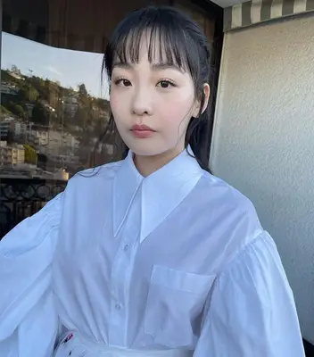 Minha Kim updo with wispy bangs in white outfit