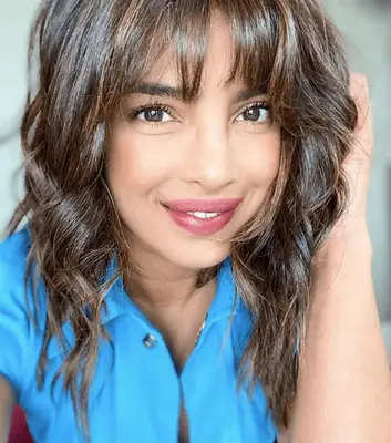 priyanka chopra jonas with layered hair and wispy bangs in blue shirt