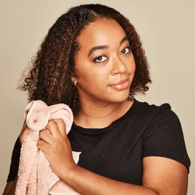 Close up of a MYM Beauty editor using a towel to dry her curly hair.