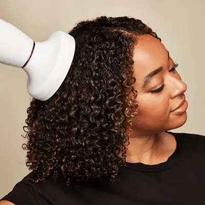 Close up of a MYM Beauty editor diffusing the roots of her curly hair.