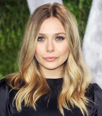 Elizabeth Olsen with rooted blonde hair and center part