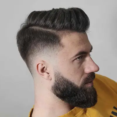 Side view of bearded man with skin fade haircut and side part