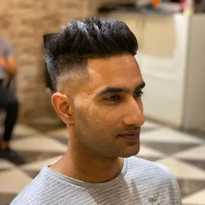 Man with mid-skin fade haircut with voluminous top and hard part