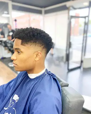 Side view of man with naturally curly drop fade haircut