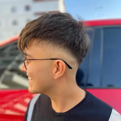 Side view of man with cropped skin fade haircut with fringe and natural straight texture