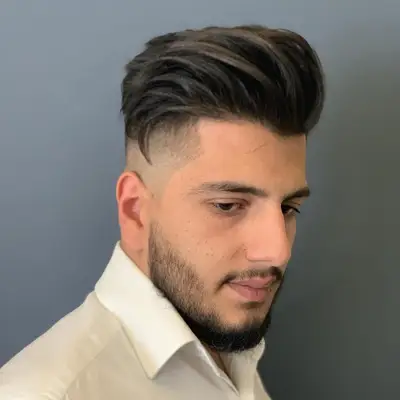 Man with soft pompadour hairstyle with side fade