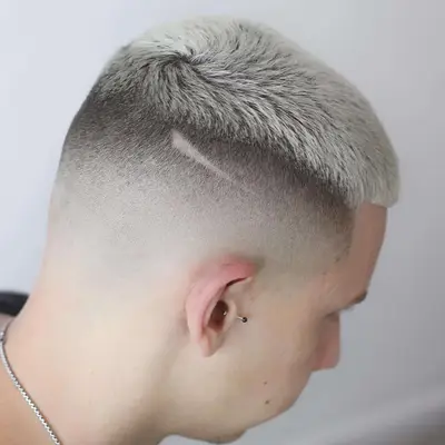 Back view of bleached platinum hair with mid-skin fade