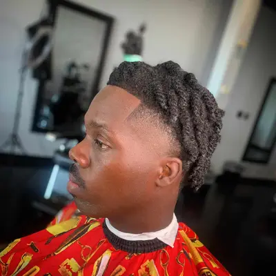 Side view of man with twisted locs with high taper fade