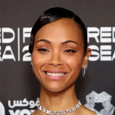 Zoe Saldana with glossy, side-swept low bun at the screening of 