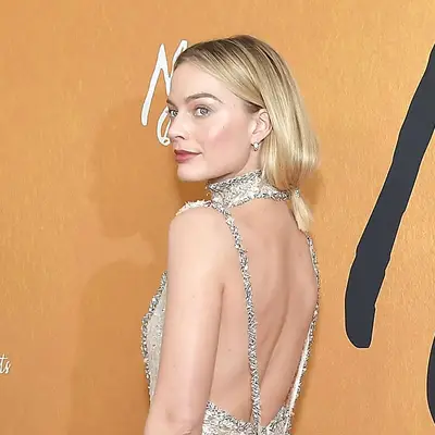 Margot Robbie wears a short, loose low ponytail hairstyle