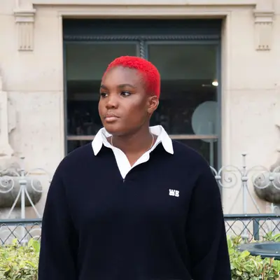 Arlo Parks with bright red buzz cut 