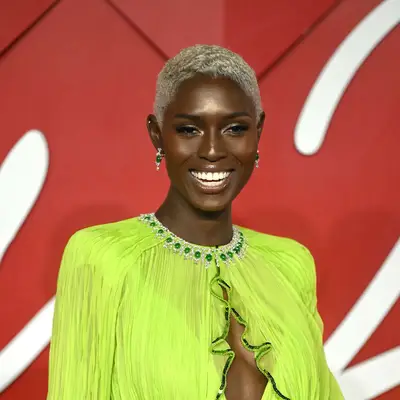 Jodie Turner-Smith with bleached buzz cut and neon green gown 