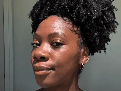 close up of woman with coily hair in bun