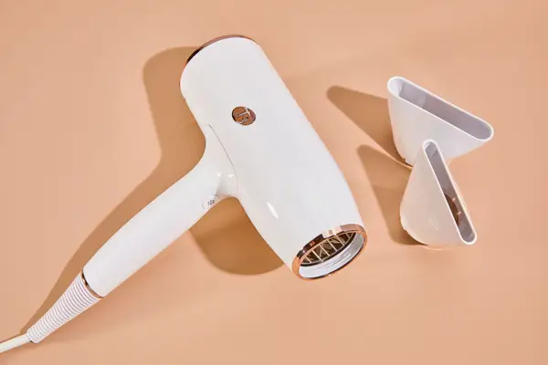 T3 AireLuxe Professional Hair Dryer and accessories on orange surface