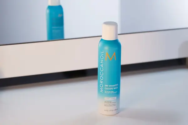 Moroccanoil Dry Shampoo Light Tones sits on white table in front of mirror