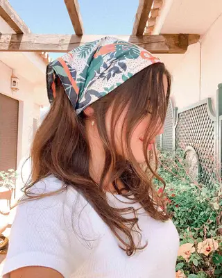 Side view of woman with bouncy blowout and leaf-patterned bandana