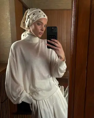 Elsa Hosk with a scarf covering her head as she takes a mirror picture