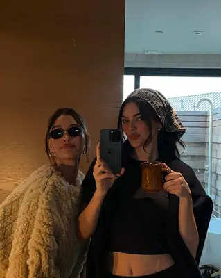 Kendall Jenner and Hailey Bieber taking a mirror selfie and Kendall is wearing a bandana head scarf