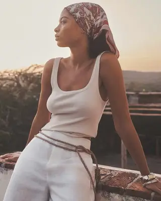 A woman in an all-neutral outfit and matching printed bandana