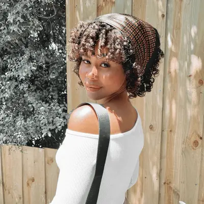 woman with short curly pixie with bangs and a bandana