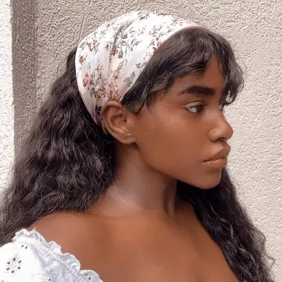 woman with long textured hair with curtain bangs and a floral scarf