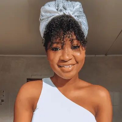 woman with curly hair in a protective bandana turban