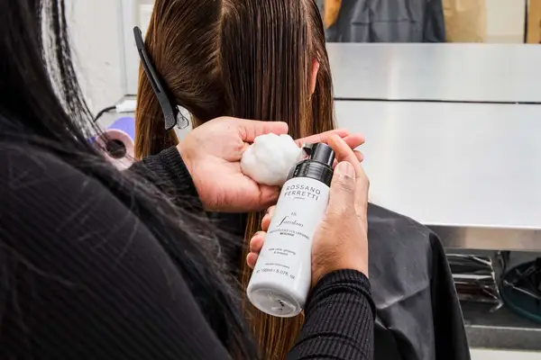 A person applies Rossano Ferretti Parma Volumizing Mousse to their hand