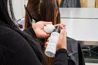 A person applies Rossano Ferretti Parma Volumizing Mousse to their hand