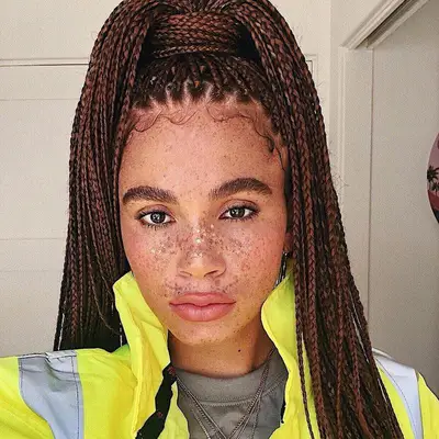 Joyjah Estrada wears auburn red box braids in a wrapped ponytail style