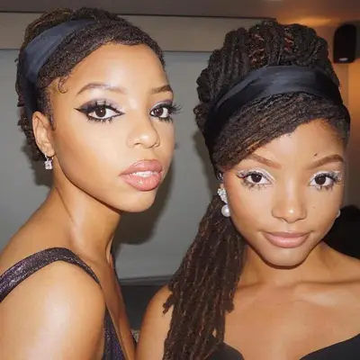 Chloe and Halle Bailey posed together with braided locs and black headbands
