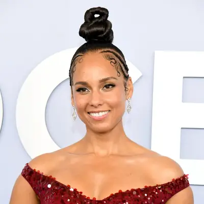 Alicia Keys wearing an elaborate twisted topknot bun and braided cornrows on the sides at the 2024 Tony Awards in New York City