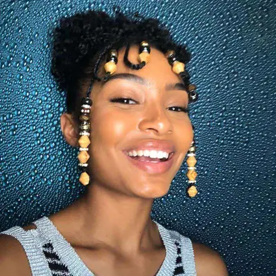 Yara Shahidi with Fulani braids with multicolored beads and curly puffy bun