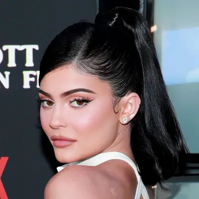 Kylie Jenner wears a retro mid-length high ponytail with wrapped base and side part