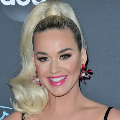 Katy Perry wears a high ponytail with wrapped base, blown out platinum ends, and natural dark blonde roots