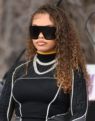 Latto with long ombre highlighted curls and large black square sunglasses